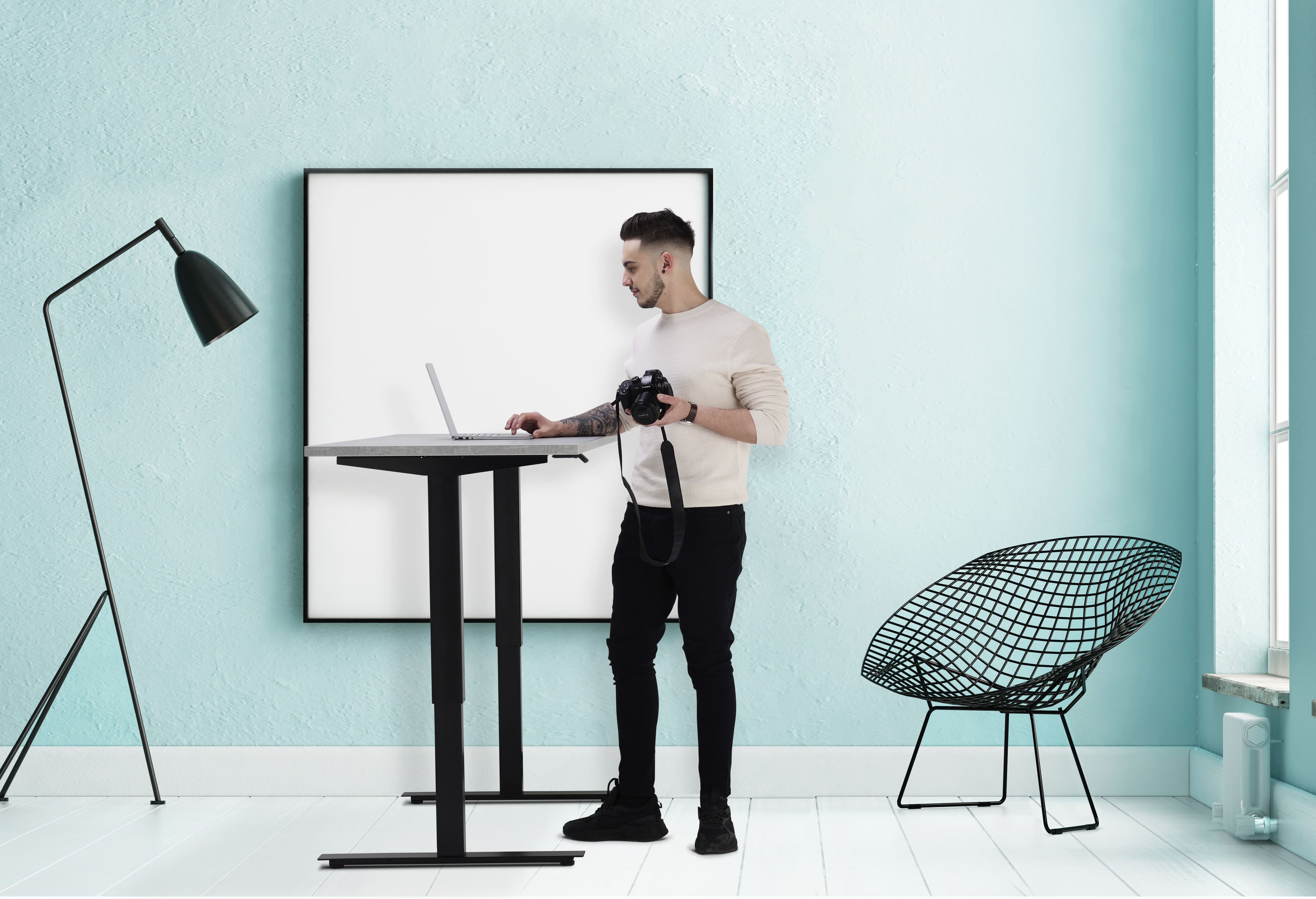 Man at standing desk with a digital camera