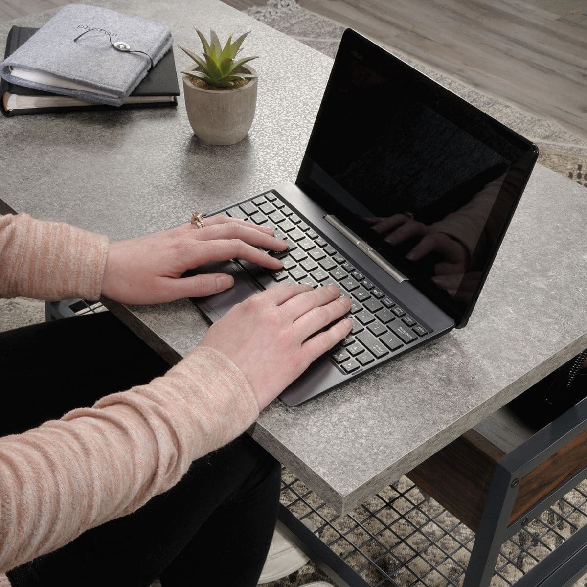 a person typing on a laptop on a table