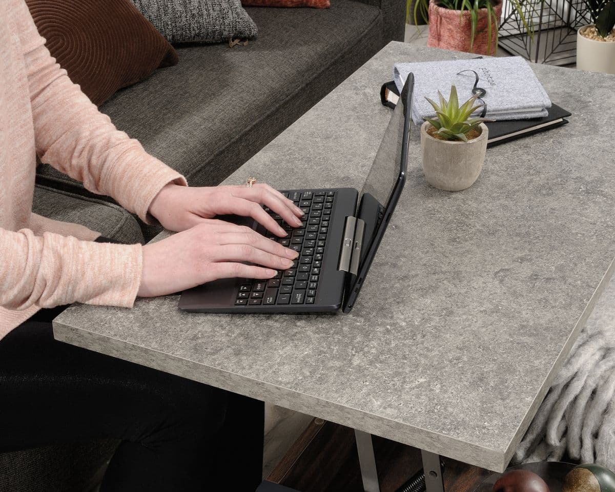 a person typing on a laptop on a table