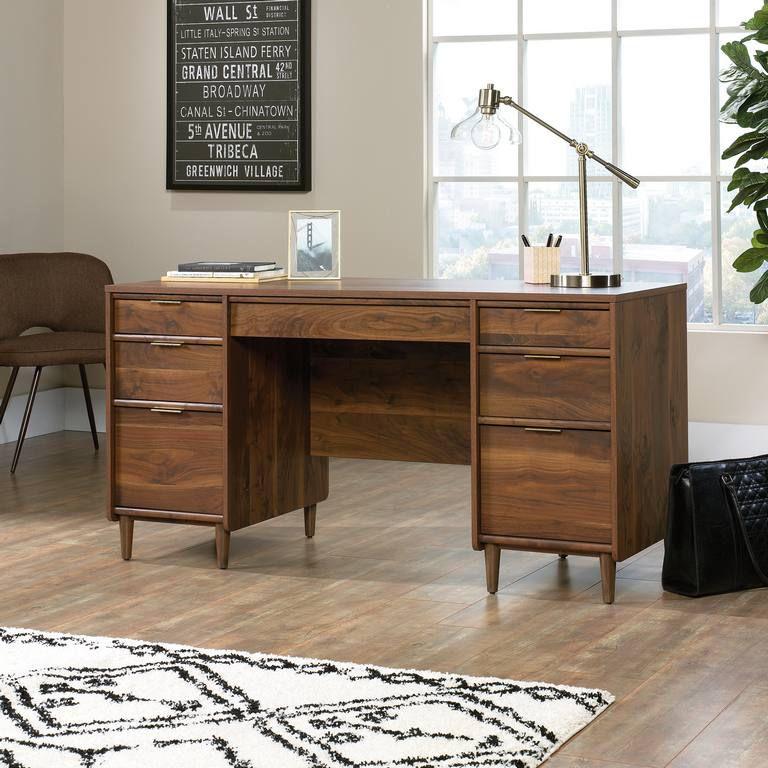 a wooden desk with a lamp and a chair