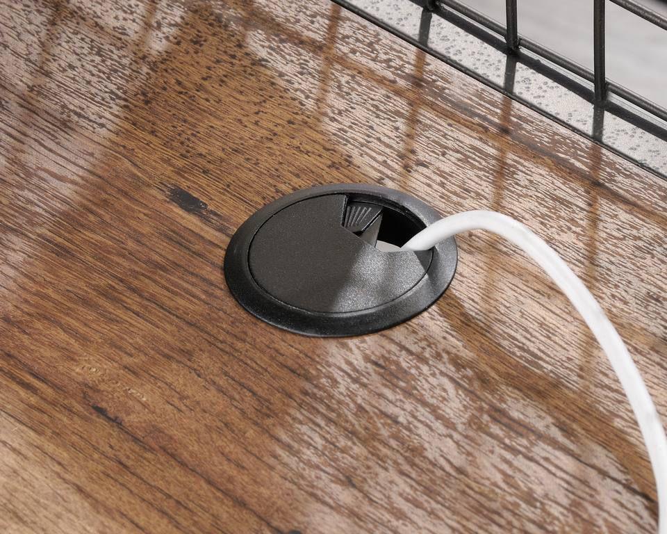 a cord is plugged into an outlet on a wooden floor