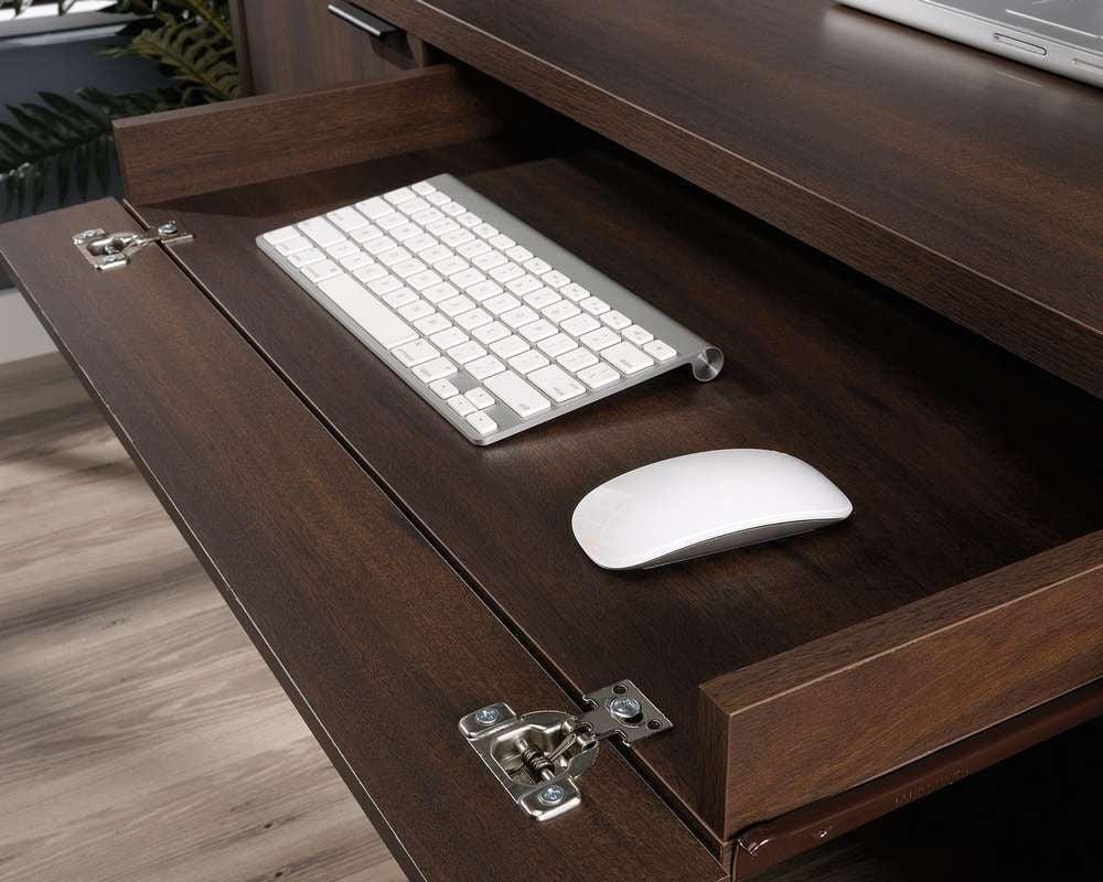 a computer desk with a keyboard and mouse