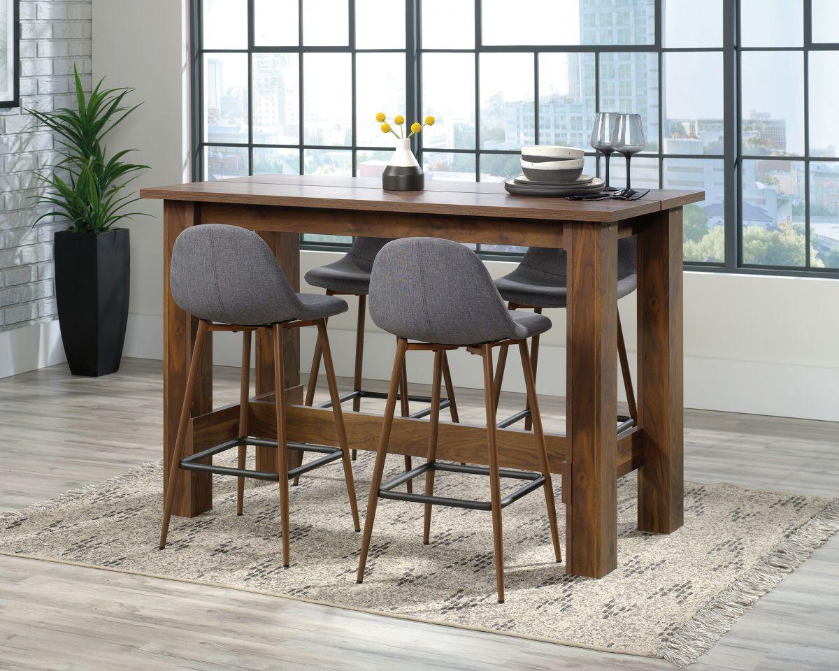 a dining table with four stools and a potted plant