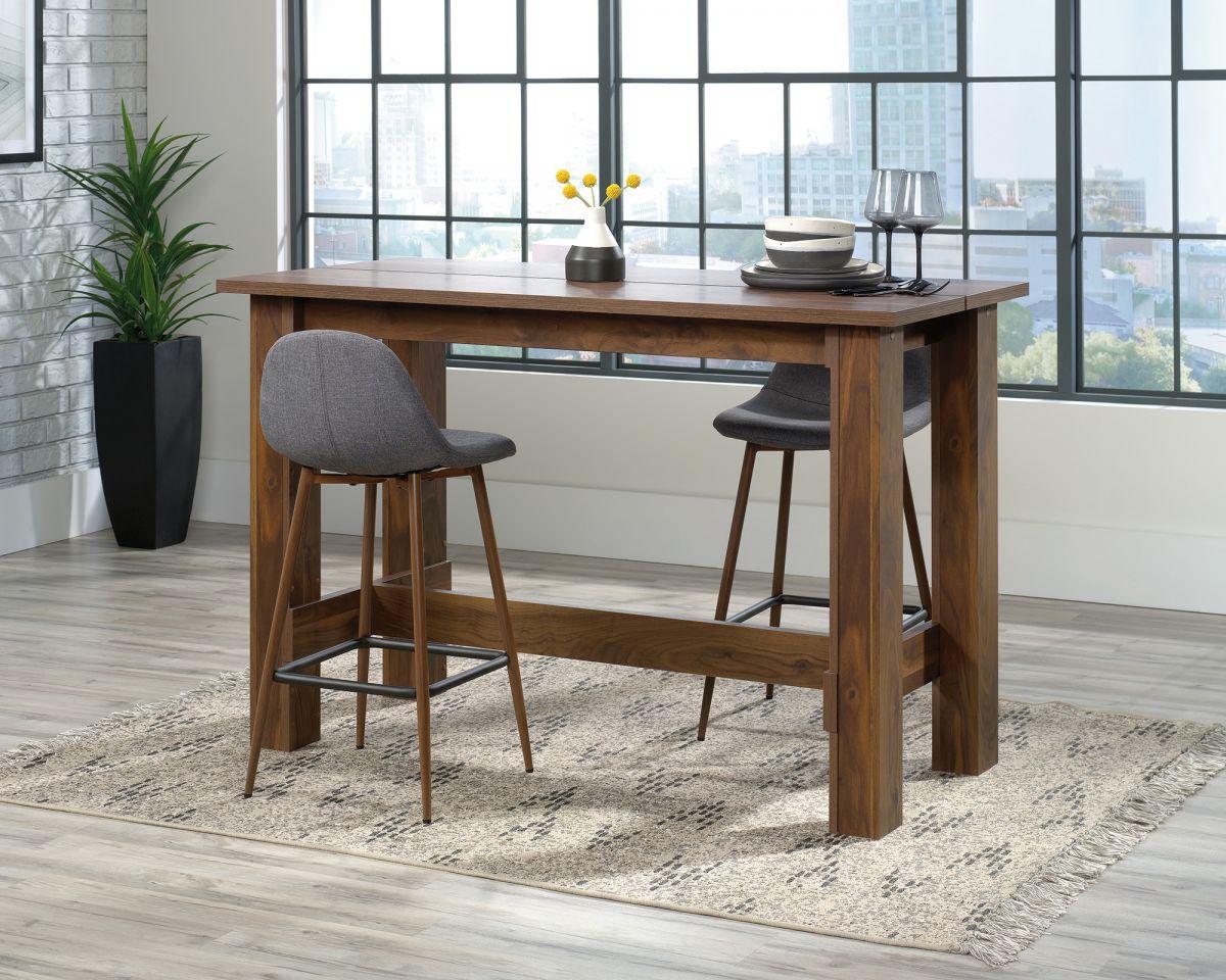 a table with two stools and a table with a vase of flowers on it