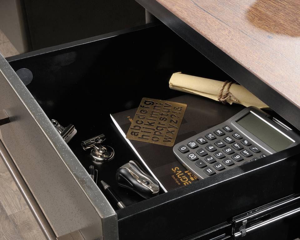 a drawer with a calculator, a pen, and other items