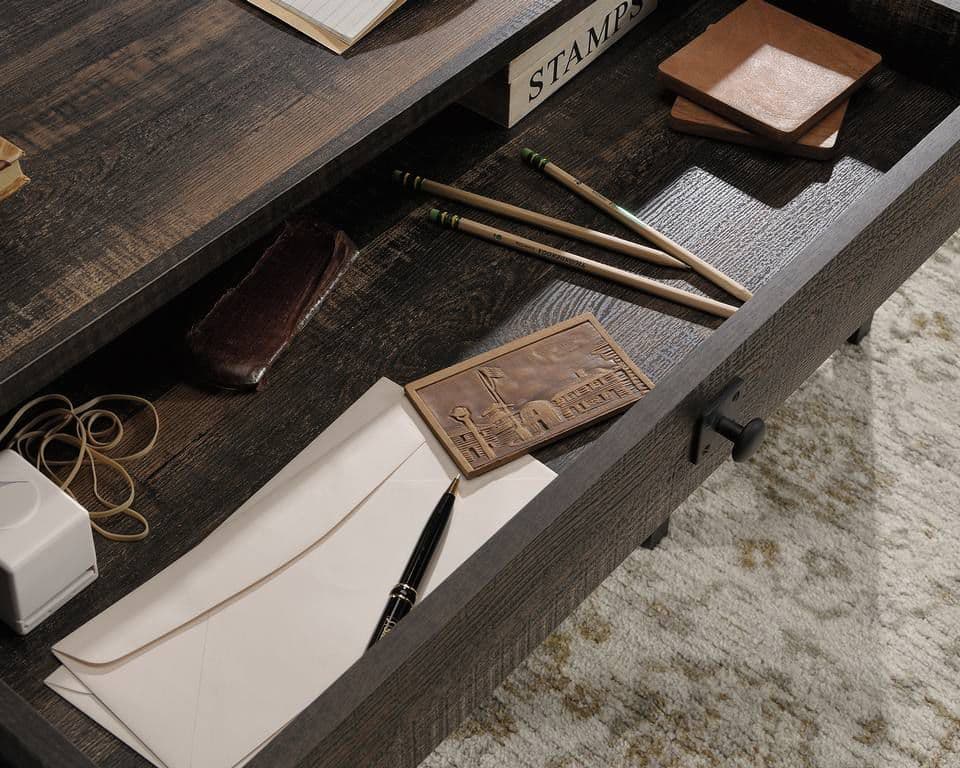 a desk with a pen, pencils, and other items on it