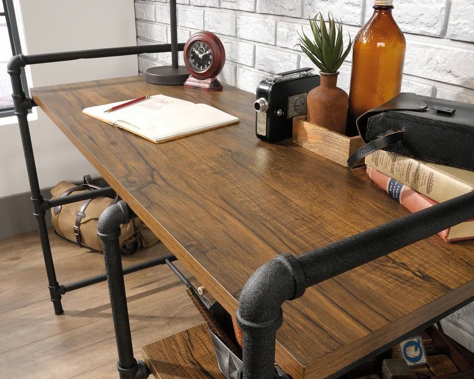 a desk with a book, a camera, a notebook and a clock on it