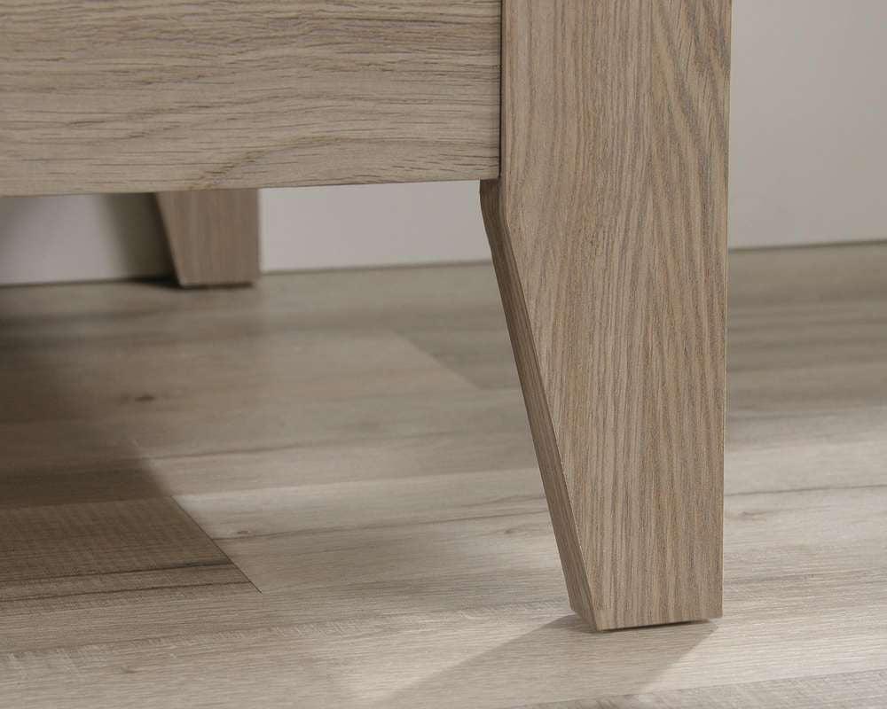 a close up of a wooden table with a white wall in the background