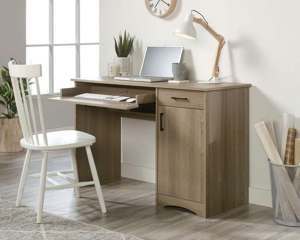 a desk with a laptop and a chair in a room