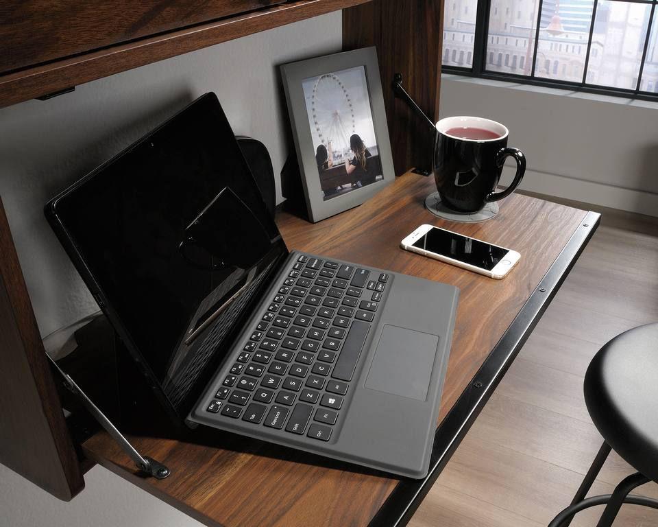 a laptop computer sitting on top of a wooden desk