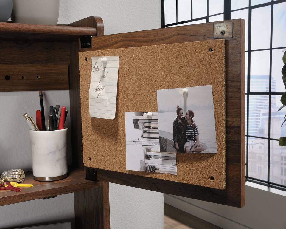 a cork bulletin board with a couple photos on it