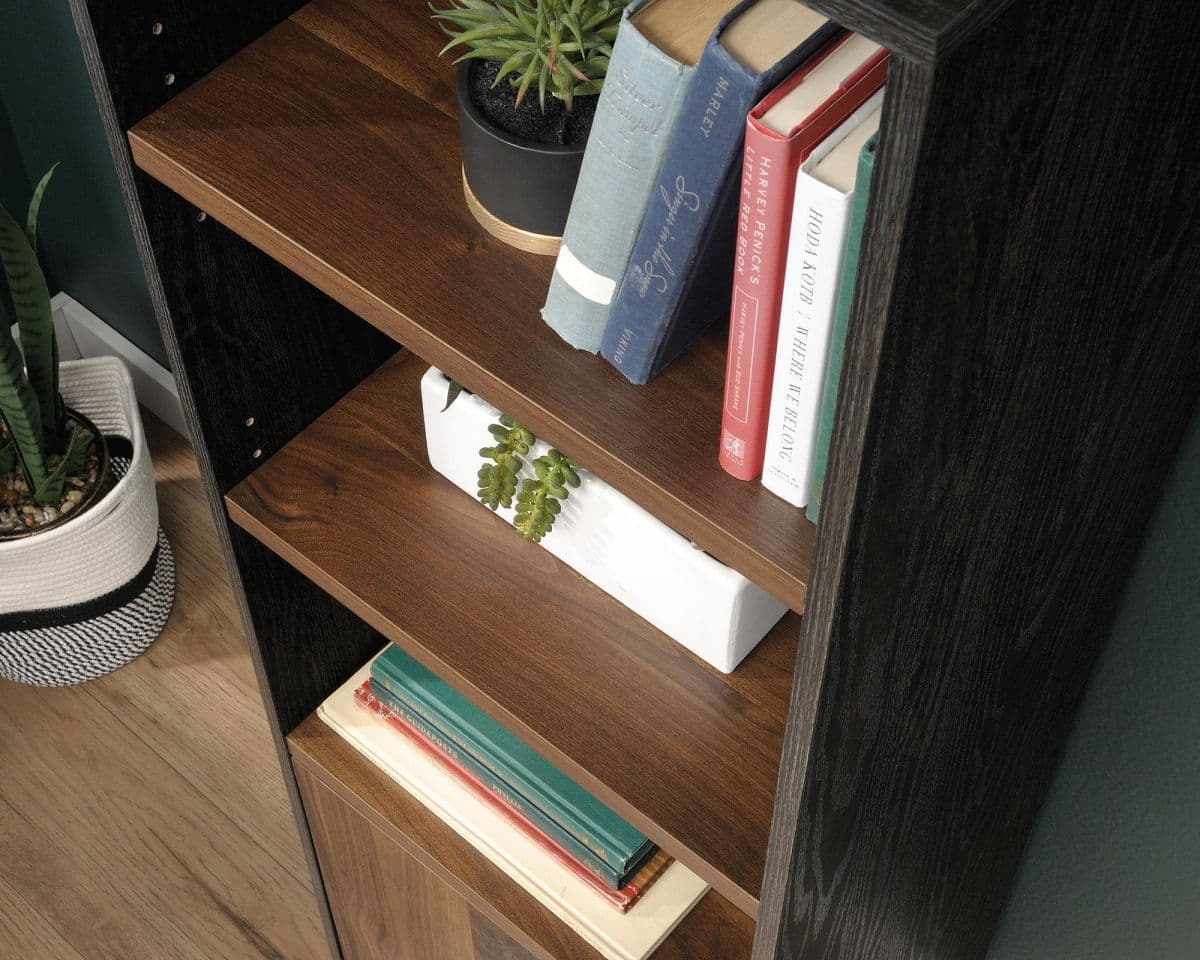 a bookshelf with books and a plant on top of it