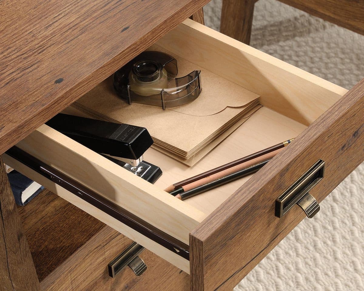 a drawer with a notepad, pen, pencils and a phone