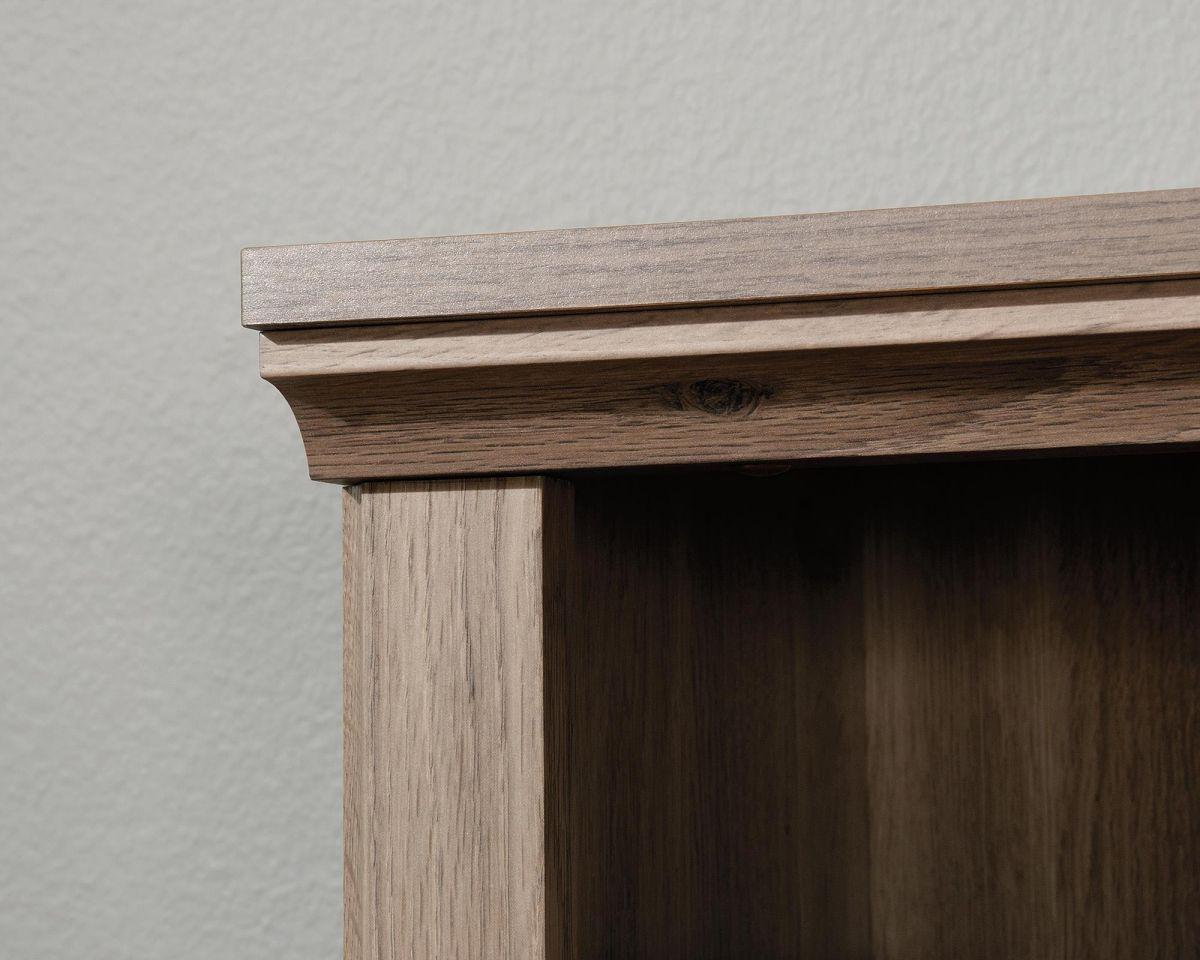 a close up of a wooden shelf with a white wall in the background