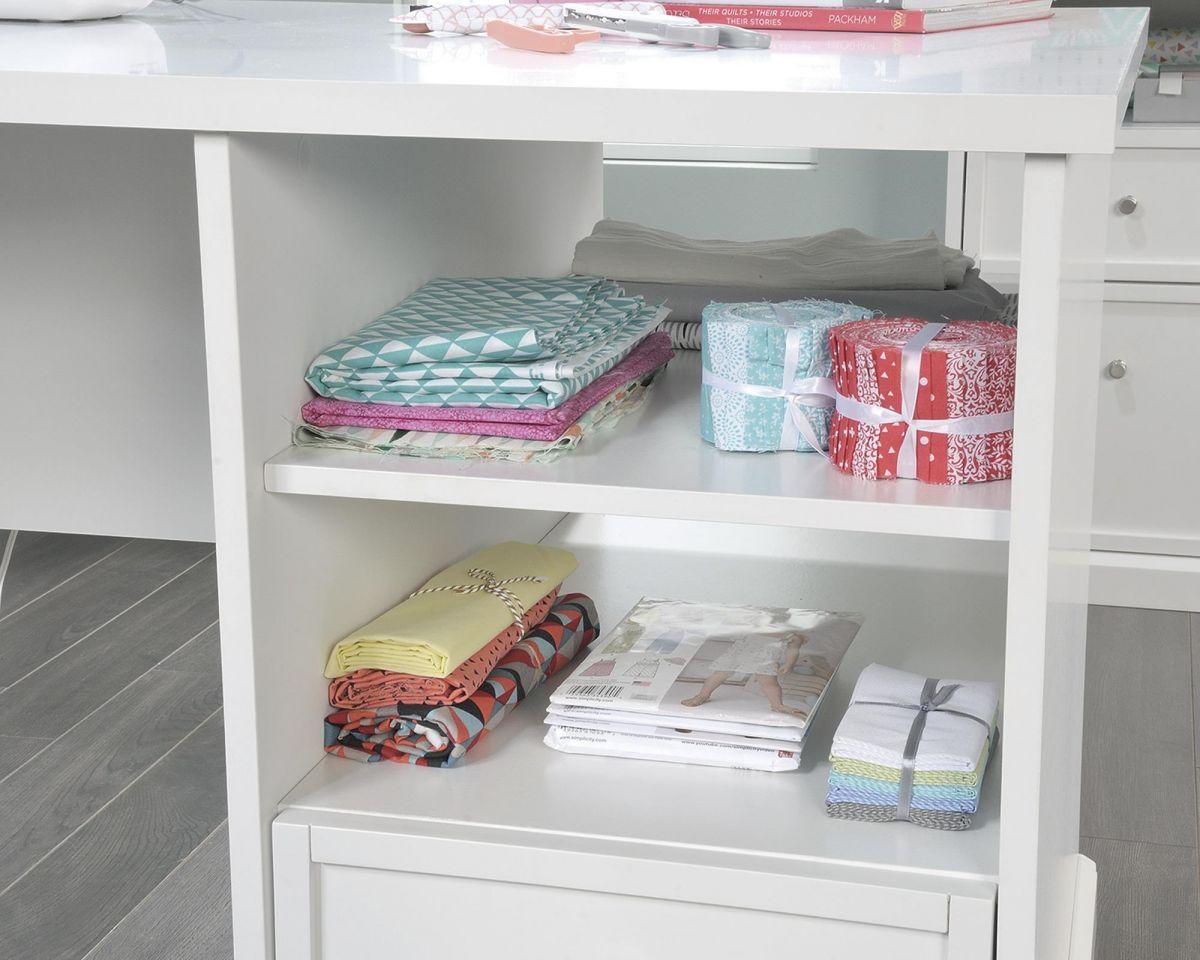 a white book shelf filled with books and wrapping paper