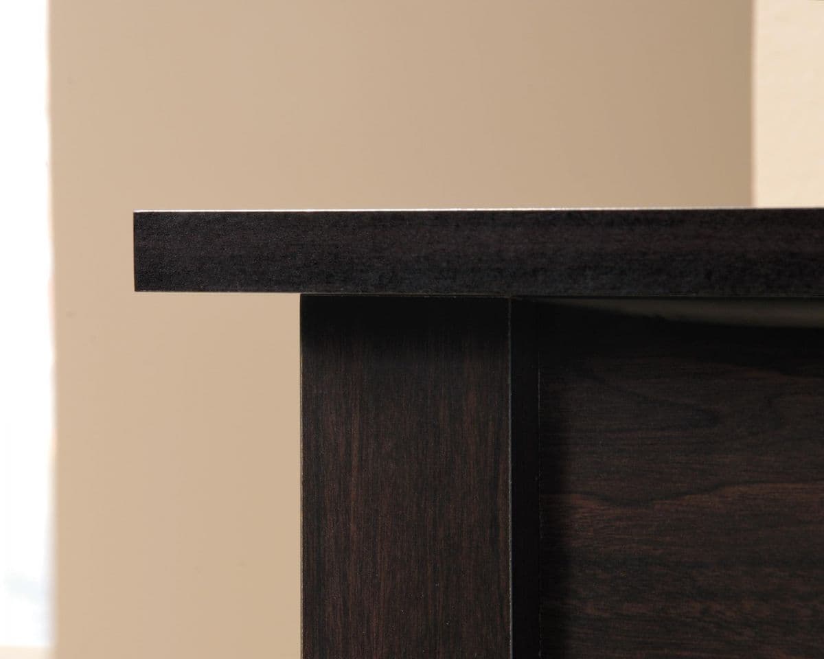 a close up of a wooden table with a white wall in the background