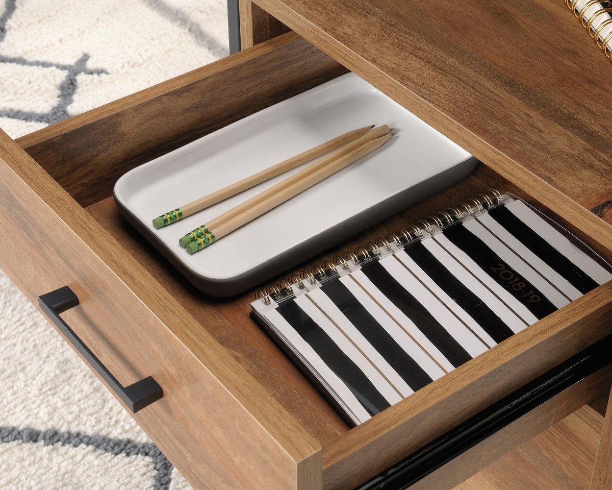 a drawer with a pen, notebook, and chopsticks in it